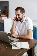 Sticker - Handsome young bearded man sitting at the table at home