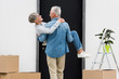 © LIGHTFIELD STUDIOS - back view of mature man holding smiling woman near new house
