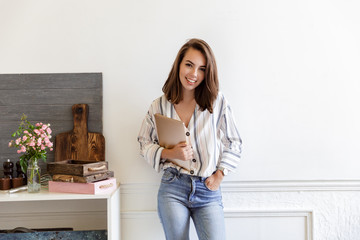 Poster - Attractive smiling young girl leaning on a wall