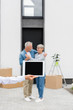 © LIGHTFIELD STUDIOS - selective focus of broker holding digital tablet and couple standing near new house on background