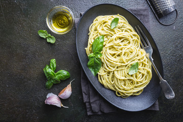 Poster - Spaghetti with homemade pesto sauce in a black plate, top view