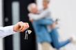 © LIGHTFIELD STUDIOS - selective focus of broker holding keys of new house and couple on background
