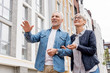 © LIGHTFIELD STUDIOS - low angle view of mature man and smiling woman looking away near new buildings