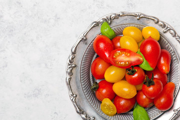 Wall Mural - Colorful organic cherry tomatoes on silver plates, light background.