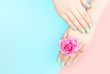 © TATIANA KIM - Female hands with mint color manicure on a pink and blue background with copy space, top view