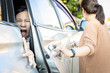 Accident,hand slammed the door,mischievous child girl was pinched her hand or fingers in the car door,asian daughter shouted in pain,woman or mother closed the car door without careful,inadvertently