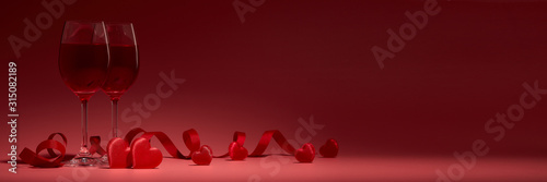 Fotomural Red hearts, glasses with wine on red background