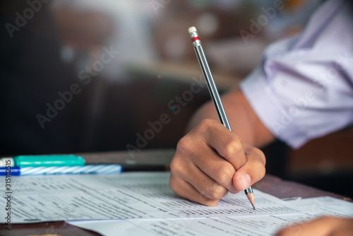 Fotografía Hand of Student doing test or exam in classroom of school with stress