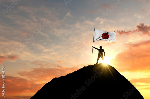 Cuadros en Lienzo Japanese flag being waved at the top of a mountain summit