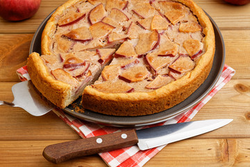 Closeup homemade pie with apple, cinnamon and yogurt topping on wooden table