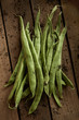 © Adam Gault/Caia Image - Still life close up fresh, organic, healthy, rustic, dirty green bean pods on wood
