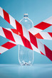 © Andy Roberts/Caia Image - Red and white tape covering plastic water bottle