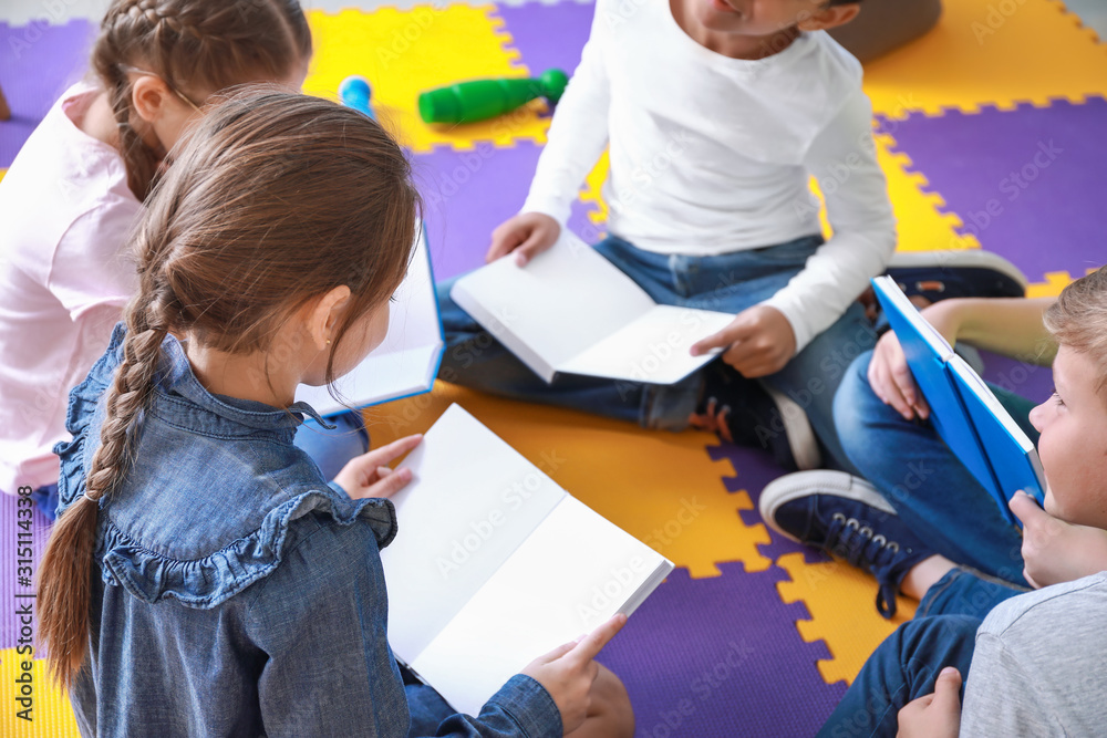 Cute little children reading books indoors