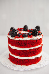 Wall Mural -  homemade red velvet cake decorated with berries on a light wooden background. valentine's day dessert