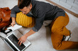 © JustLife - Businessman working in chilled working space. Young man using laptop while laying on floor.