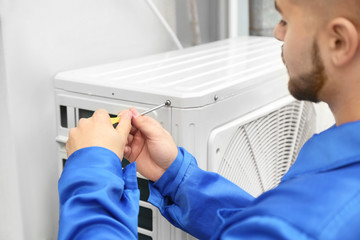 Wall Mural - Male technician installing outdoor unit of air conditioner