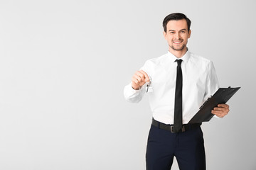 Sticker - Male real estate agent with key on light background