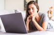 © dianagrytsku - Smiling young woman laying on couch and using laptop