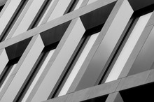 Geometric Pattern From Part Of Building Facade. Modern Architecture Of Commercial Building Walls And Windows Made Of Glass.