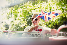 Smiling Woman Waving British Flag On Double-decker Bus