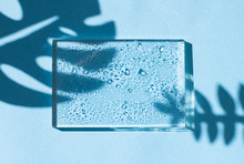 Concept Blue Summer Frame , A Glass Border With Water Drops And A Shadow Of Tropical Leaves. Copy Space