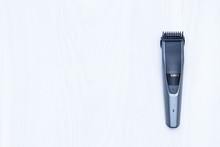 Hair Trimmer On White Wooden Background. Copy Space, Top View.