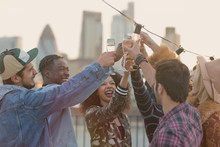 Young Adult Friends Toasting Champagne Glasses At Rooftop Party
