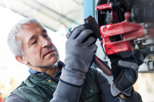 Close Up Focused Mechanic Replacing Brake Pads In Auto Repair Shop