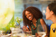 © Justin Pumfrey/Caia Image - Women friends laughing and dining at restaurant table