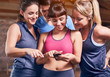 © Trevor Adeline/Caia Image - Young women and man in sports clothing texting with cell phone