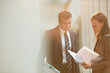 © Tom Merton/Caia Image - Businessman and businesswoman reviewing paperwork in office lobby