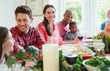 © Robert Daly/Caia Image - Portrait smiling woman enjoying Christmas dinner with family at table
