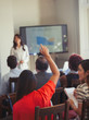 © Paul Bradbury/Caia Image - Businesswoman in audience asking question at business conference