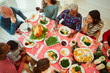 © Robert Daly/Caia Image - Overhead view multi-ethnic multi-generation family enjoying Christmas dinner at table