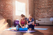 © Trevor Adeline/Caia Image - Fitness instructor and young woman using digital tablet in gym studio