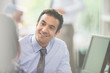 © Martin Barraud/Caia Image - Attentive, smiling businessman listening to colleague in meeting