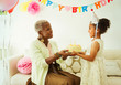 © Robert Daly/Caia Image - Grandmother and granddaughter holding cake at birthday party