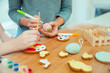 © Robert Daly/Caia Image - Close up mother and daughter decorating Easter eggs and cookies