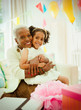 © Robert Daly/Caia Image - Portrait smiling grandmother granddaughter hugging at birthday party