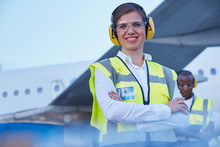 Portrait Smiling Female Air Traffic Controller Standing Near Airplane
