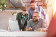 © Agnieszka Olek/Caia Image - Smiling design professionals using graphics tablet at laptop in office