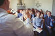 © Paul Bradbury/Caia Image - Business people in audience watching businessman leading business conference