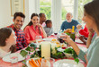 © Robert Daly/Caia Image - Multi-ethnic multi-generation family enjoying Christmas dinner at table