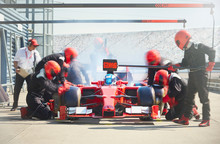 Pit Crew Working On Formula One Race Car In Pit Lane