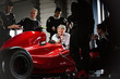 © Sam Edwards/Caia Image - Manager pit crew working on formula one race car in dark repair garage