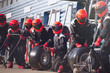 © Sam Edwards/Caia Image - Pit crew ready with tires in formula one pit lane