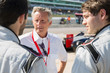 © Sam Edwards/Caia Image - Manager talking to formula one drivers on sports track