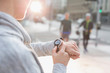© Martin Barraud/Caia Image - Female runner checking smart watch on urban street