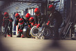 © Sam Edwards/Caia Image - Pit crew preparing tires in formula one pit lane