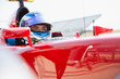 © Sam Edwards/Caia Image - Focused formula one race car driver wearing helmet, looking away